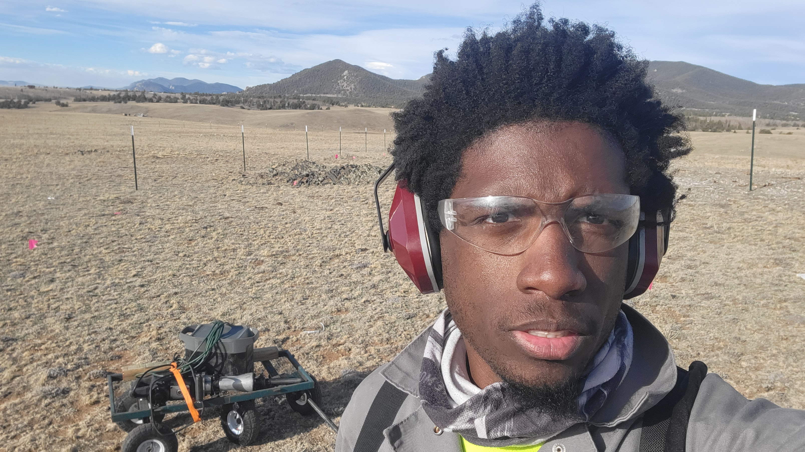 Me standing behind the jackhammer and battery we used to get the fence posts in.